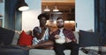 Happy young Caucasian man and African woman sit at home watching dramatic movie together, eating popcorn slow motion. Royalty Free Stock Photo