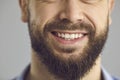 Closeup studio shot of lower part of face of happy smiling young man with brown beard Royalty Free Stock Photo