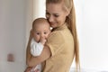 Loving young mom lull hug newborn baby infant