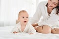 A young mother teaches her newborn son to crawl on the bed Royalty Free Stock Photo