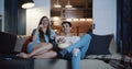 Happy young Caucasian romantic couple talk watching movies at home on the couch, eating snacks and smiling slow motion. Royalty Free Stock Photo