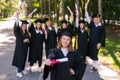 Happy young caucasian woman celebrating graduation with classmates. A group of graduate students outdoors. Royalty Free Stock Photo