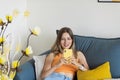 Happy young caucasian blonde woman relaxing at home alone, sitting on couch in comfortable pose, blogger sharing good Royalty Free Stock Photo