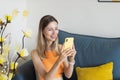 Happy young caucasian blonde woman relaxing at home alone, sitting on couch in comfortable pose, blogger sharing good Royalty Free Stock Photo