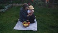 Happy Young Cheerful Mother Holding Baby Eating Fruits On Green Grass. Mom Adorable Infant Child Playing Outdoors With Royalty Free Stock Photo