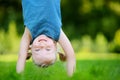 Happy young child playing head over heels on a grass in spring park Royalty Free Stock Photo