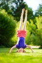 Happy young child playing head over heels on green grass in spring park Royalty Free Stock Photo