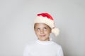 Happy young Christmas girl wearing red Santa hat looking up on white background Royalty Free Stock Photo