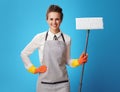 Happy young cleaning lady in apron with mop on blue