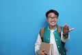 Young Asian male student smiling and do calling gesture with hand, marketing concept Royalty Free Stock Photo