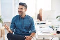 Happy young corporate business man talking, thinking and working at a desk in an office at work. One worker, employee or Royalty Free Stock Photo