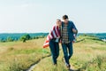 happy young couple with american flag on rural meadow independence Royalty Free Stock Photo