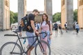 happy young couple with backpacks and bicycle at Pariser Platz Berlin