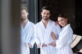 happy young couple in bathrobes smiling at camera Royalty Free Stock Photo