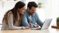 Happy young couple bonding laughing using laptop sit at table Royalty Free Stock Photo