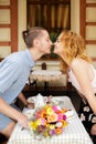 A beautiful young couple is kissing in a cafe. Summer vacation with your beloved Royalty Free Stock Photo