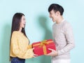 Happy young couple celebrating for chinese new year and holding gift box.Isolated on blue background