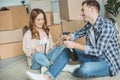 happy young couple celebrating relocation with champagne while sitting near cardboard boxes Royalty Free Stock Photo