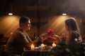 Happy young couple celebrating Valentines day having romantic dinner at home. Loving man giving gift box his woman Royalty Free Stock Photo