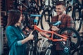 Happy Young Couple Chooses Kids Bicycle in Store