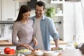 Happy young couple cooking healthy food together in kitchen Royalty Free Stock Photo