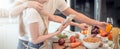 Happy young couple cooking together in the kitchen at home. looking at tablet Royalty Free Stock Photo