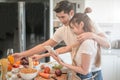 Happy young couple cooking together in the kitchen at home. looking at tablet Royalty Free Stock Photo