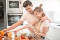 Happy young couple cooking together in the kitchen at home. looking at tablet Royalty Free Stock Photo