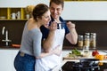 Happy young couple cooking together in the kitchen at home.