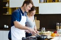 Happy young couple cooking together in the kitchen at home. Royalty Free Stock Photo