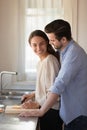 Happy young couple cooking together, standing in kitchen Royalty Free Stock Photo