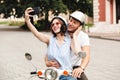 Happy young couple in crash helmets making selfie on smartphone Royalty Free Stock Photo