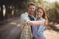 Happy young couple dancing at olive farm during sunny day Royalty Free Stock Photo