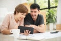 Couple with digital tablet and blueprints planning their new moving house. Royalty Free Stock Photo