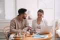 Happy young couple discussing family budget and new house buying at home. Mortgage concept Royalty Free Stock Photo