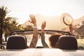 Happy young couple doing road trip in tropical city - Travel people having fun driving in trendy convertible car Royalty Free Stock Photo