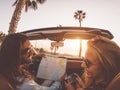 Happy young couple doing road trip in tropical city - Travel people having fun driving in trendy convertible car Royalty Free Stock Photo