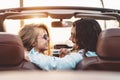 Happy young couple doing road trip in tropical city - Travel people having tender moments in trendy convertible car Royalty Free Stock Photo