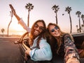 Happy young couple doing road trip in tropical city - Travel trendy people having fun driving in convertible car Royalty Free Stock Photo