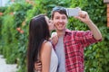 Happy young couple doing selfie by smart mobile phone in the city. Royalty Free Stock Photo