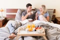 Happy young couple drinking coffee and orange juice Royalty Free Stock Photo