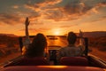 Happy young couple driving along country road in convertible car at sunset. Freedom adventure road trip, car rental concept. Royalty Free Stock Photo