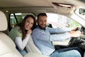 happy young couple driving their new car at a car dealership looking at the camera with a smile Royalty Free Stock Photo