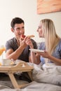 Happy young couple having breakfast in bed Royalty Free Stock Photo