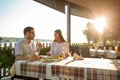 Happy young couple eating fish dinner and drinking wine in riverside restaurant Royalty Free Stock Photo