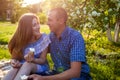 Young couple eating ice-cream and chatting outside. Woman and man chilling out in spring garden at sunset. Picnic Royalty Free Stock Photo