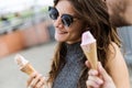 Happy young couple eating ice cream in the street. Royalty Free Stock Photo