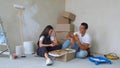Happy young couple eating pizza during break in repairment
