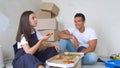 Happy young couple eating pizza during break in repairment