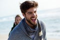 Happy young couple enjoying the day in a cold winter on the beach. Royalty Free Stock Photo